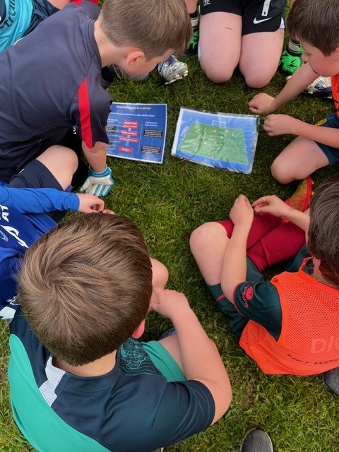 CFC-philosophy-boys-gathered-in-circle-reviewing-tactics