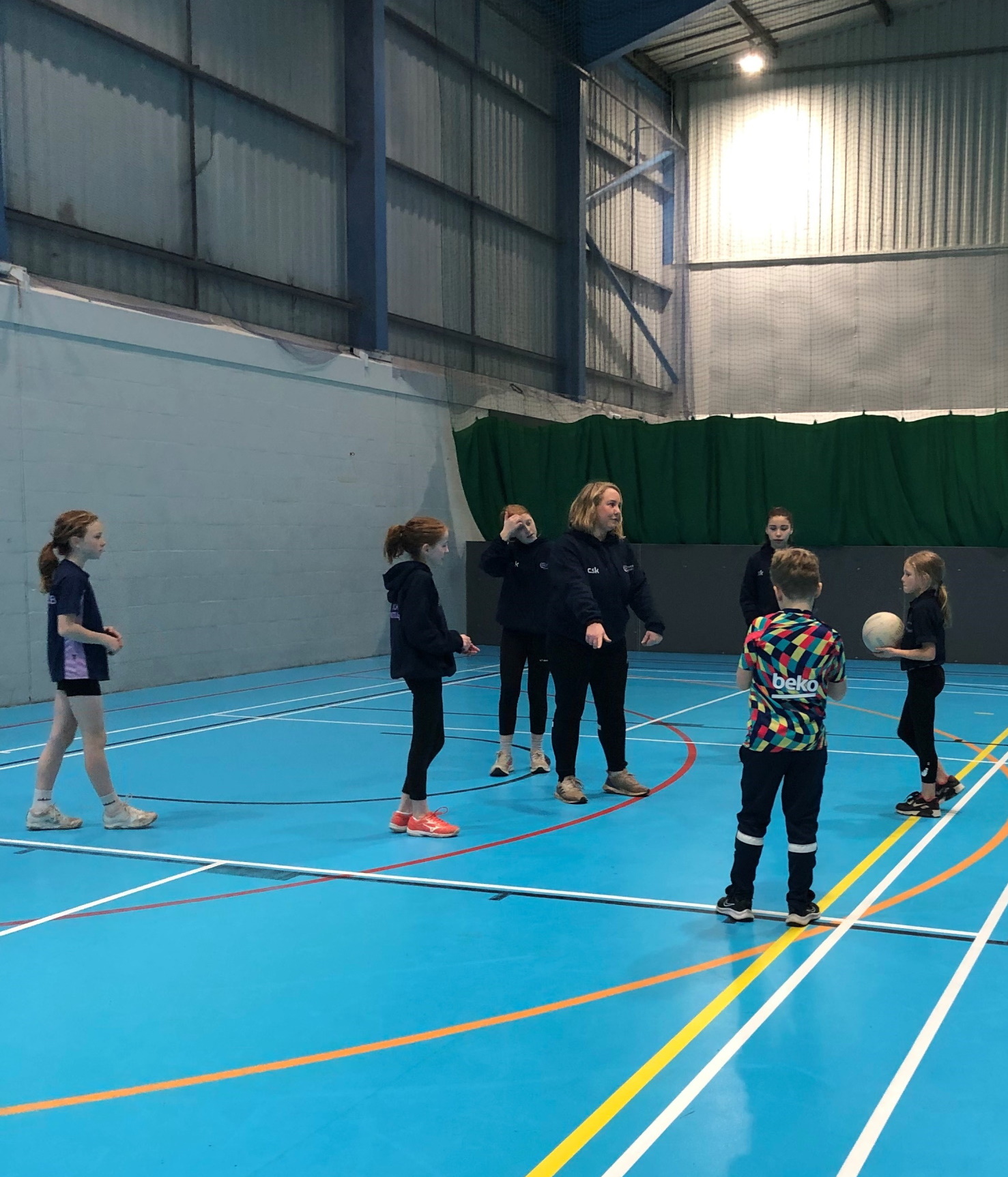 Coach Becky Evans delivering a session in a sports hall