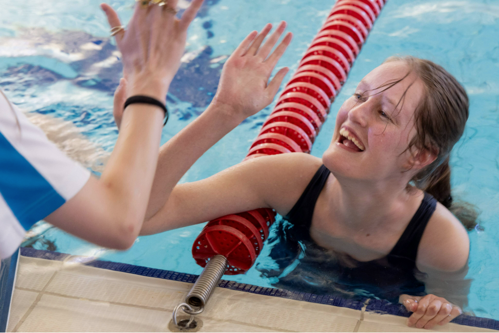 girl-in-pool-high-fiving-coach-at-the-end-of -the-lane