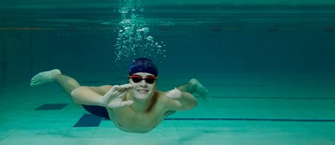 Teenage boy swimming underwater in a swimming pool