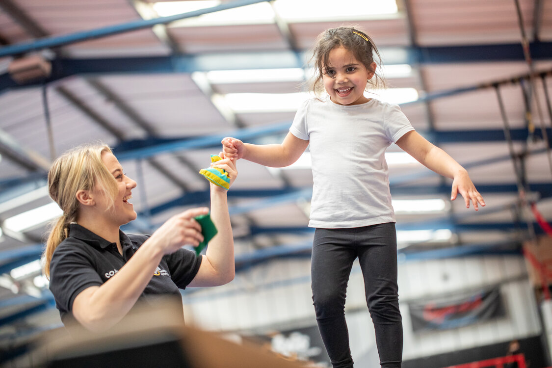 emale-coach-and-young-girl-on-balancing-beam-in-gymnastics-session