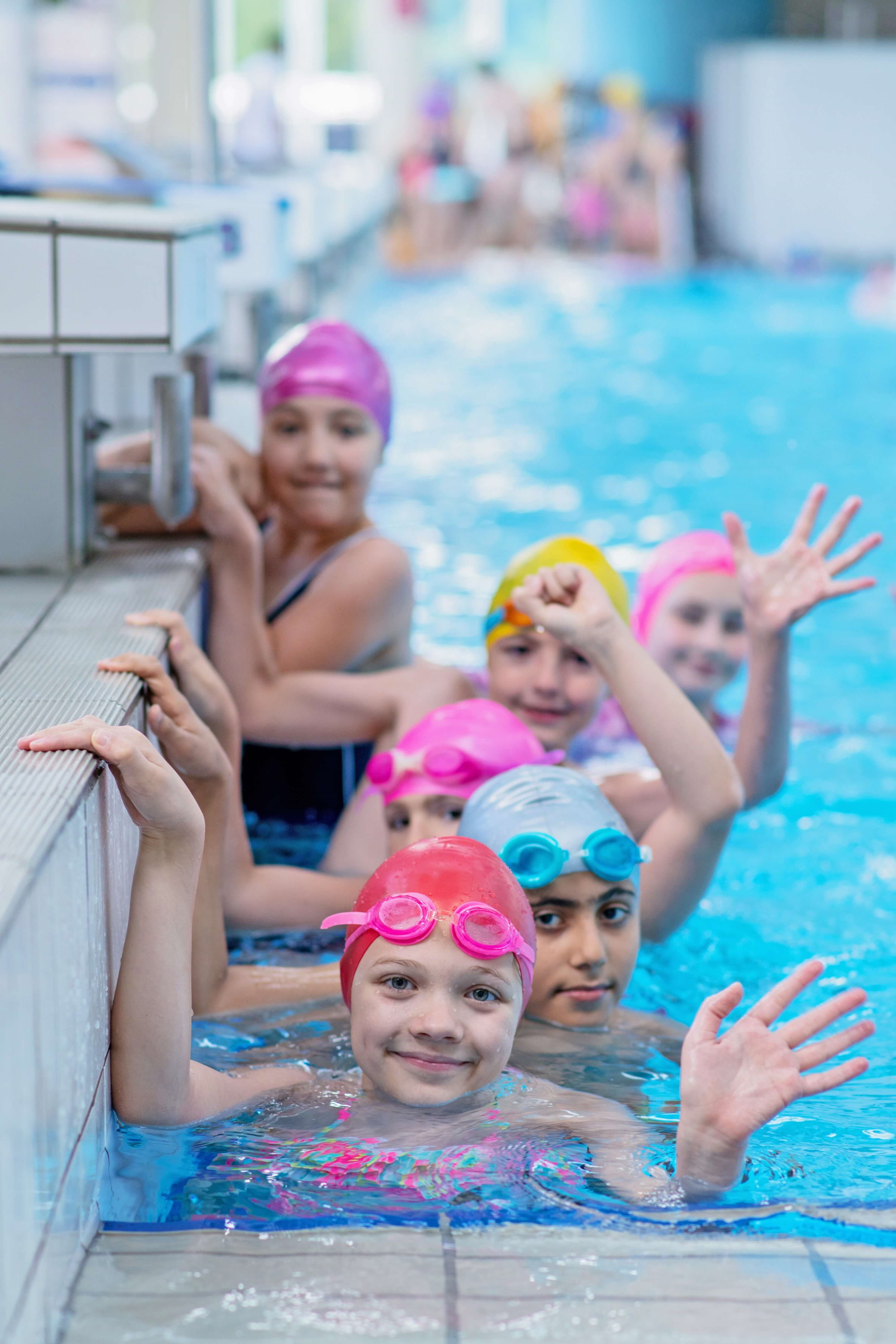 Happy swimming class waving at the camera