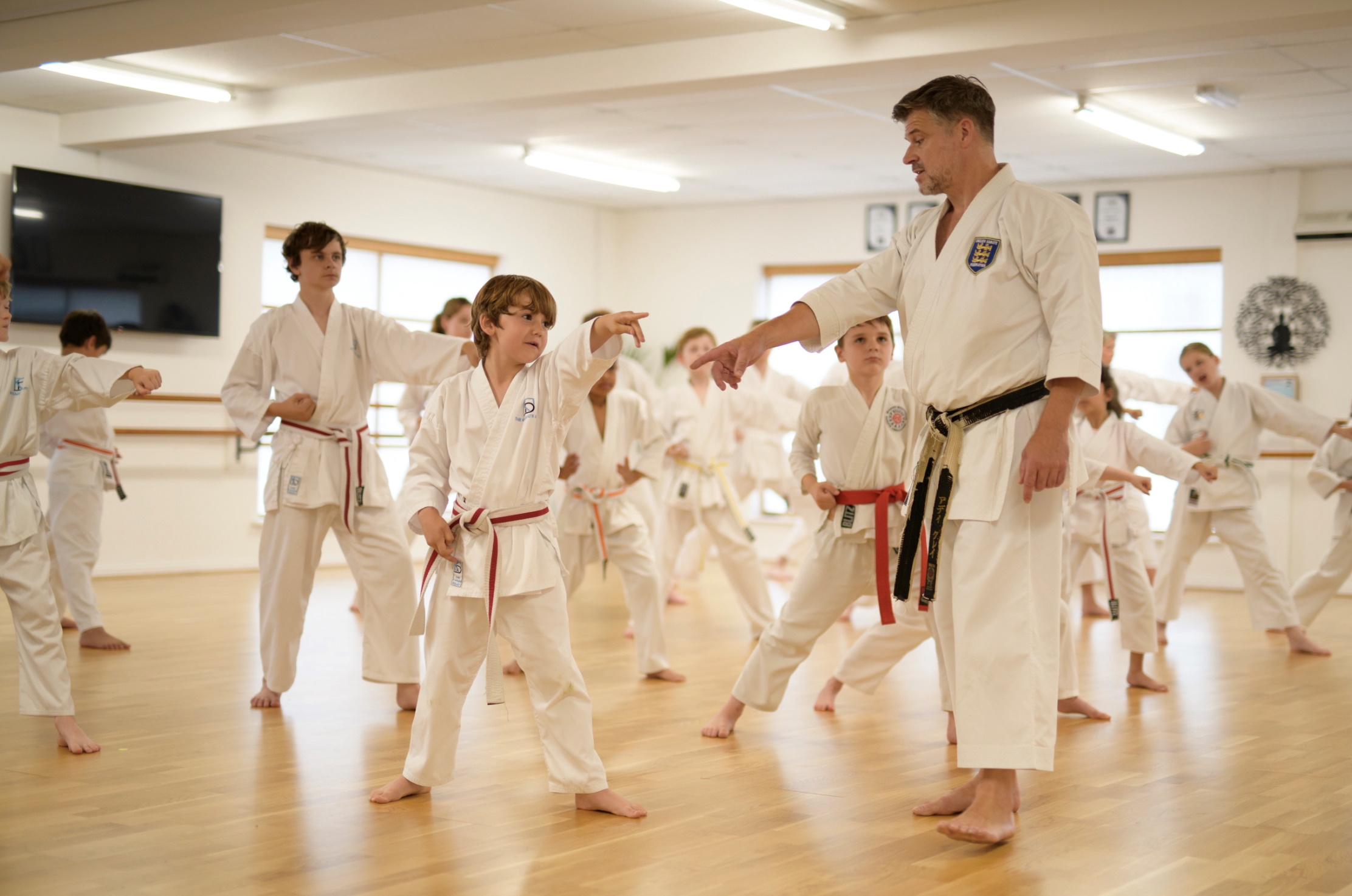 Karate coach walks in front of his students giving instructions during a drill