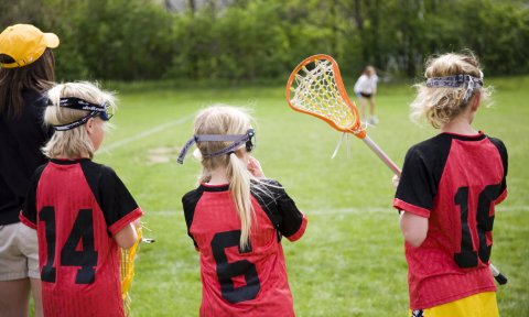 A lacrosse coach and participants looking out over the field