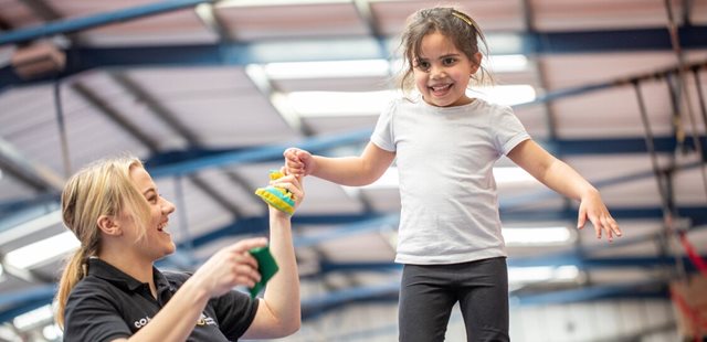 irl-and-coach-in-gymnastics-session-holding-hands-for-balance