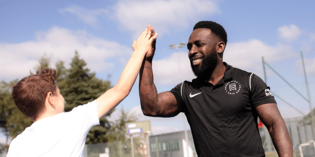 Smiling coach gives young boy a high five