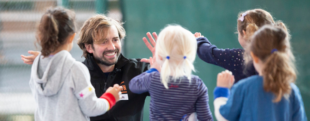 Tennis Coach Matt high fives young children