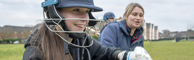 Cara cricket coach with young girl cricketer