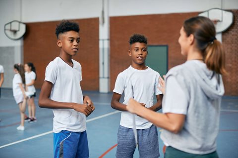 Coach chatting to participants in a sports hall