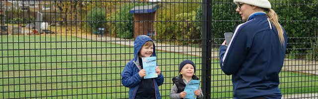 Coach and two young participants standing outside a sports pitch