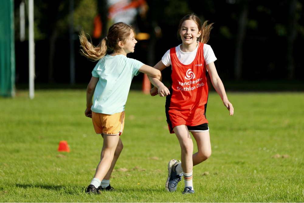 two-girls-playing-in-a-field-launghing-linking-arms