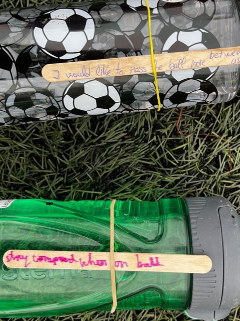 CFC-philosophy-olly-pop-sticks-on-water-bottles-with-text-about-players-aspirations-for-the-game
