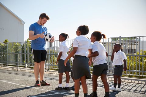 Sports coach talking to school pupils