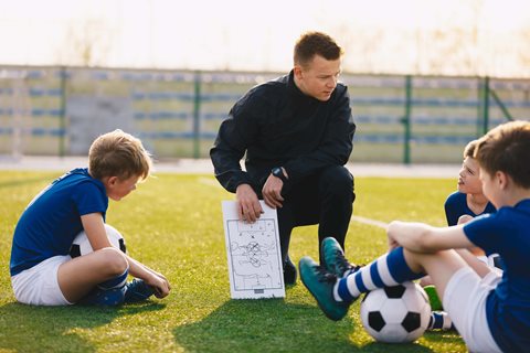 Coach talking strategy with young players