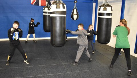 Young boxers hit the bags in the boxing gym during a training session