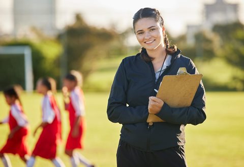 Smiling coach holding clipboard