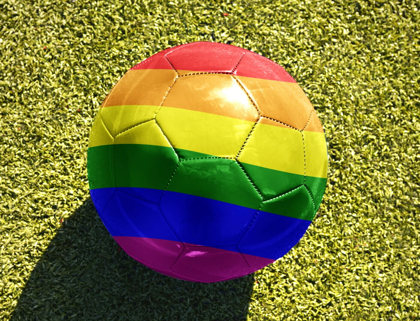 Football with a rainbow flag design on grass