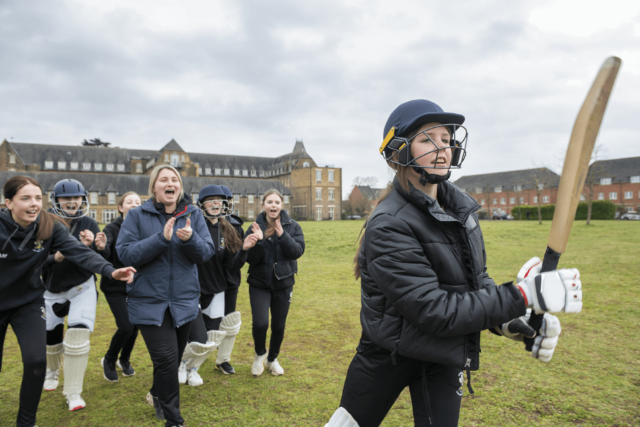 Teen girl batting a cricket ball