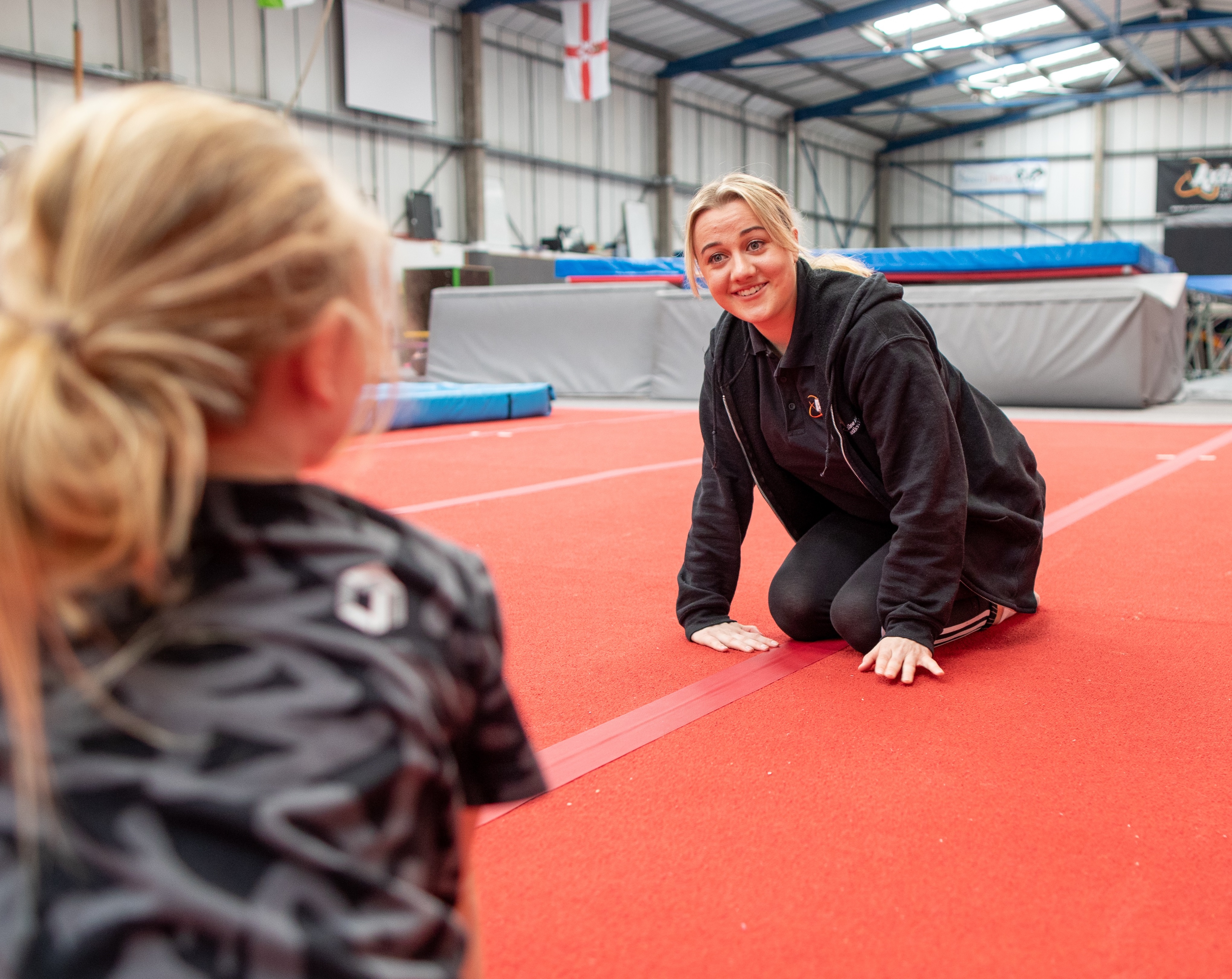 How to coach trampolining to kids - coach Hermione listening to a child