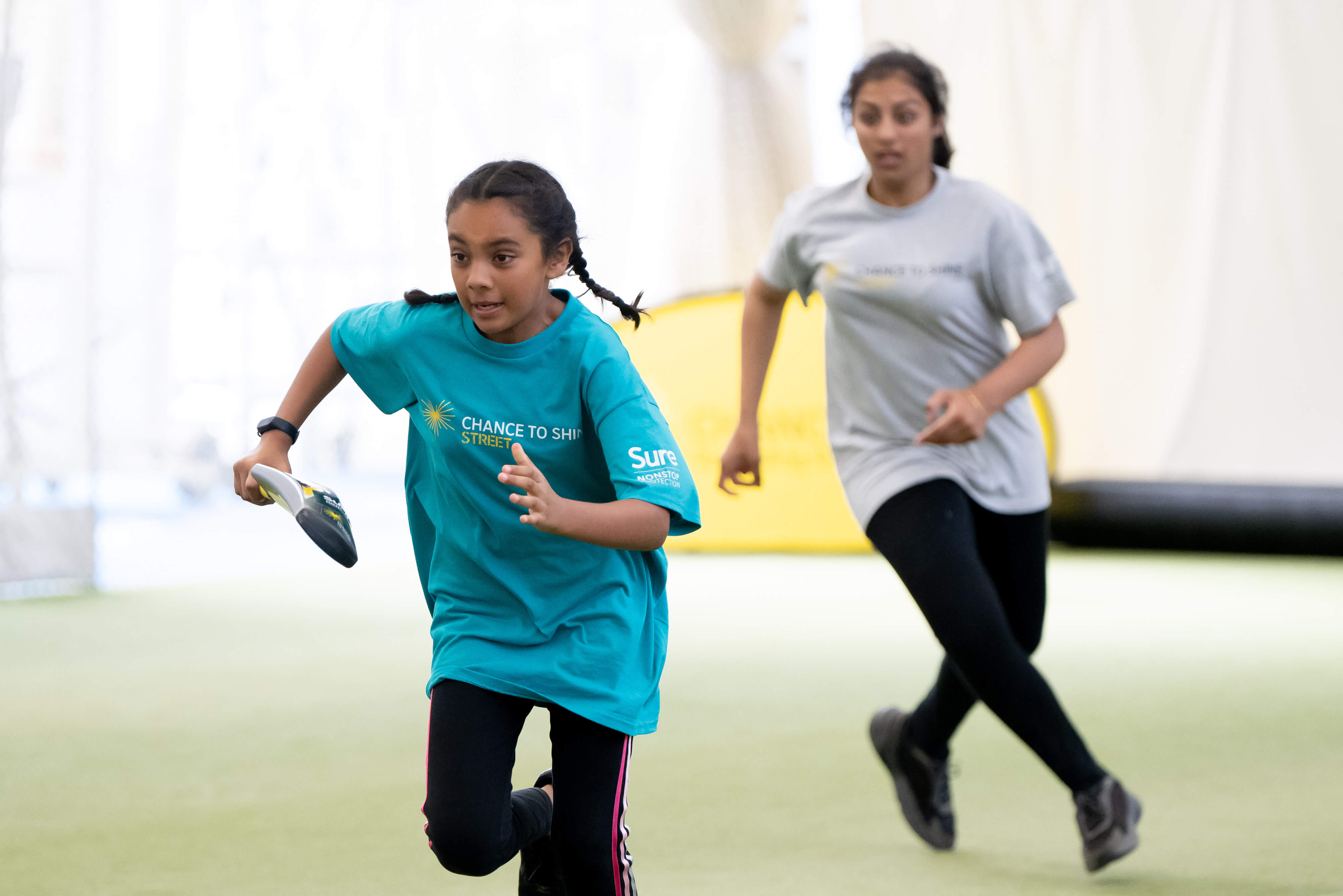 Two girls playing cricket in a Chance to Shine coaching sessions. 