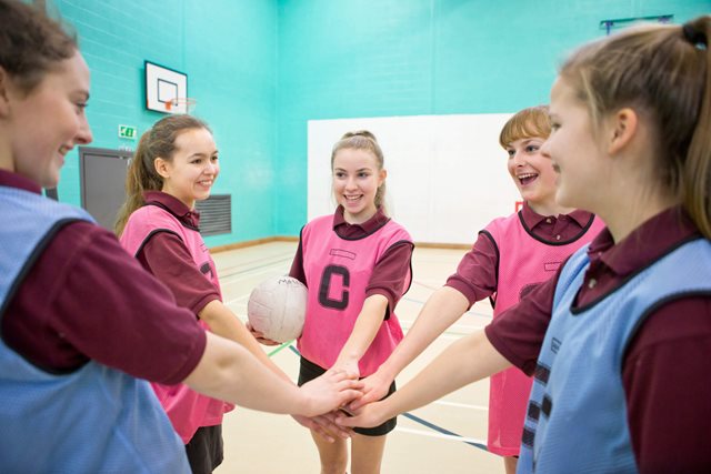 netball-huddle-with-girls-hands-in-the-middle
