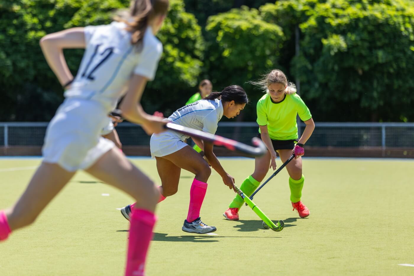 Young women playing hockey outdoors