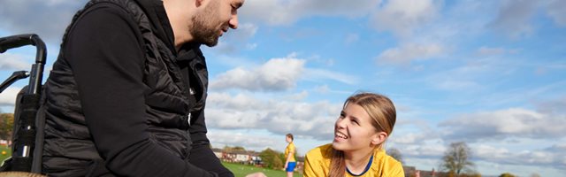 Coach in a wheelchair talking to a young participant