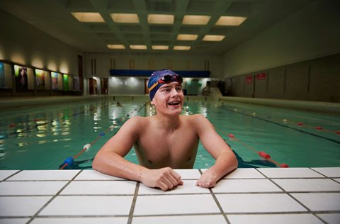 Swimmer talking to his coach on the sidelines