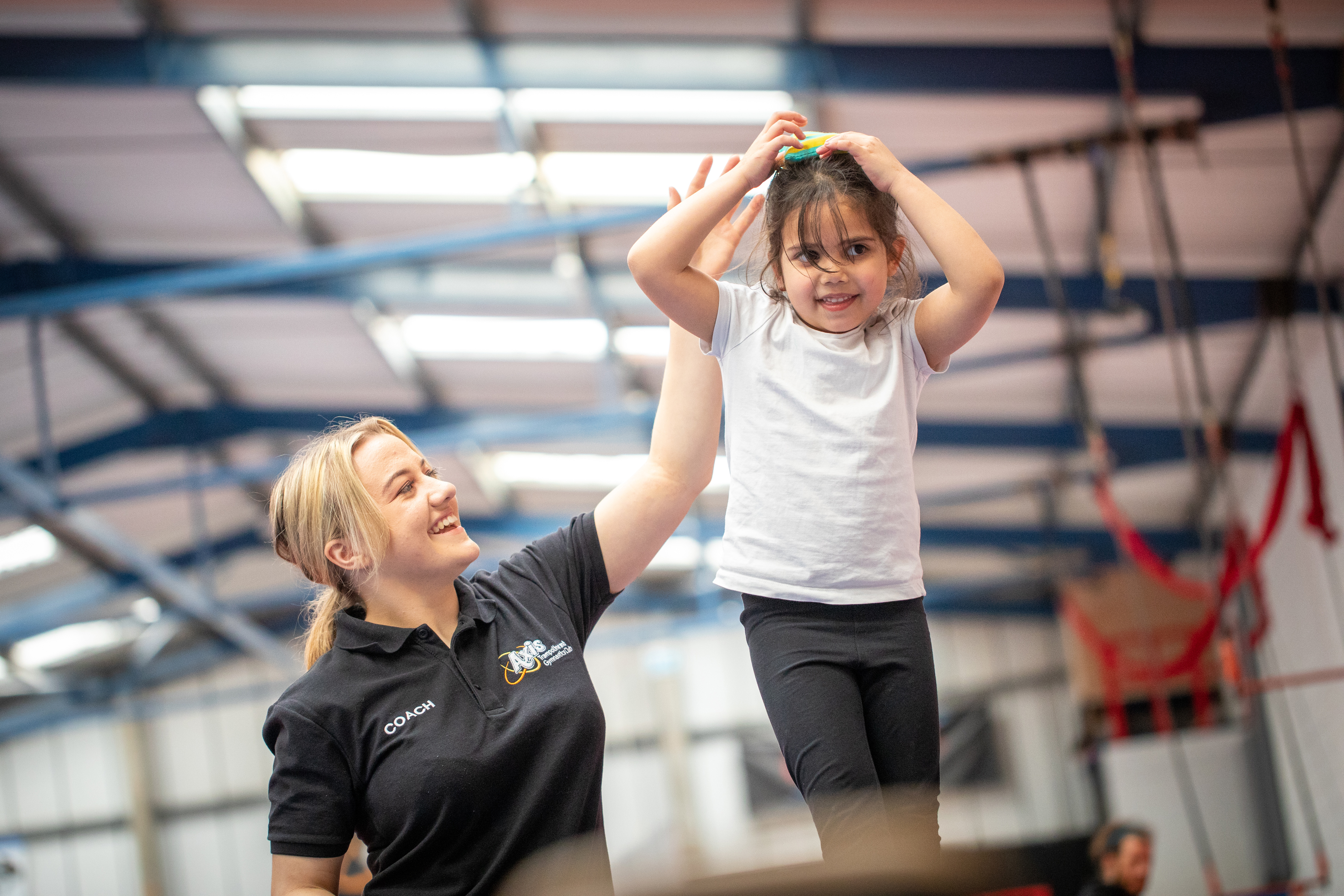 How to coach trampolining to kids - coach Hermione helps a girl with a balancing exercise