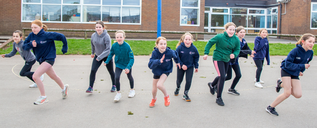 Netball team runs towards camera