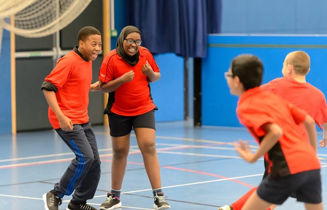 A group of joyful children laughing and having fun in a sports hall