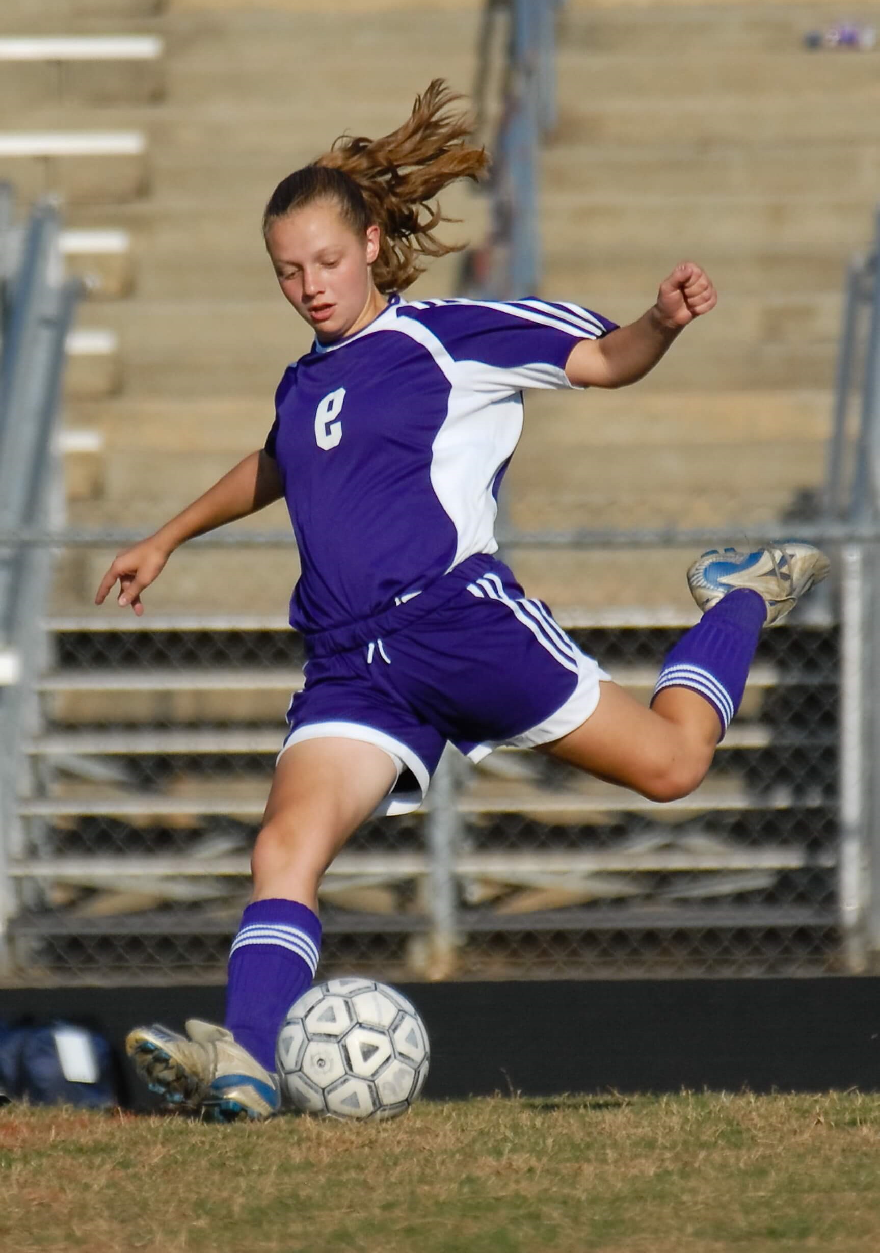 Girl kicking football