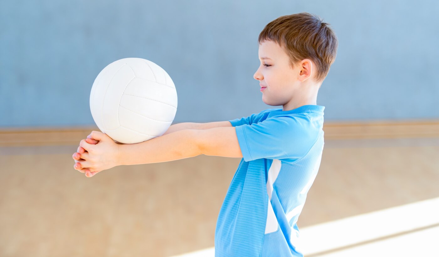 Child practising volleyball technique