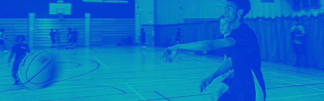 boys-in-sports-hall-chasing-a-ball-as-it-flies-through-the-air