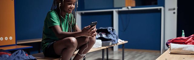 Young girl on her phone in locker room